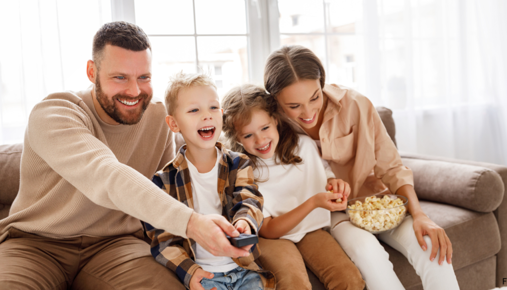 Sala de home theater com sofá confortável, tela de projeção exibindo imagens abstratas, e um ambiente acolhedor com iluminação suave e uma tigela de pipoca, ideal para assistir filmes relacionados à Constelação Familiar.