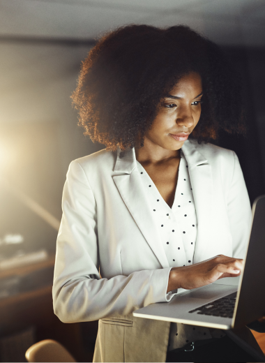 Mulher profissional analisando informações em um laptop, transmitindo foco, confiança e produtividade.

